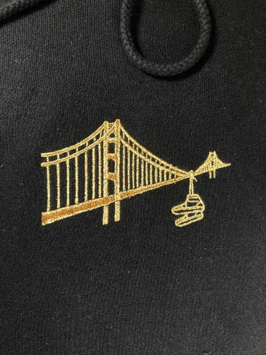 black hoodie with shoes or sneakers hanging from golden gate bridge